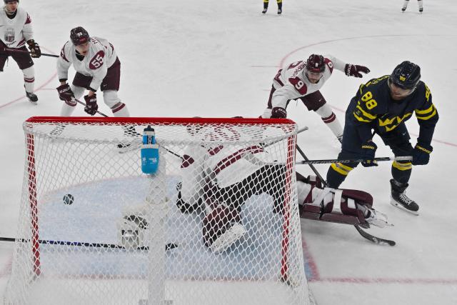Sweden's #88 William Nylander (R) scores their 5-1 goal during the men's qualification play-off ice hockey match between Sweden and Latvia at the Milano Santagiulia Ice Hockey Arena during the Milano Cortina 2026 Winter Olympic Games in Milan, on February 17, 2026. (Photo by Alexander NEMENOV / POOL / AFP)