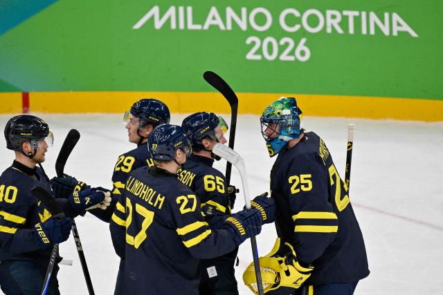 Sweden's players celebrate winning the men's qualification play-off ice hockey match between Sweden and Latvia at the Milano Santagiulia Ice Hockey Arena during the Milano Cortina 2026 Winter Olympic Games in Milan, on February 17, 2026. (Photo by Alexander NEMENOV / AFP)
