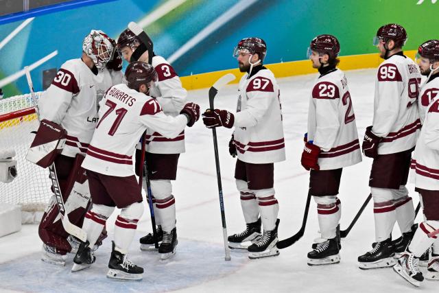 Latvia playrs react at the end of the men's qualification play-off ice hockey match between Sweden and Latvia at the Milano Santagiulia Ice Hockey Arena during the Milano Cortina 2026 Winter Olympic Games in Milan, on February 17, 2026. (Photo by Alexander NEMENOV / AFP)