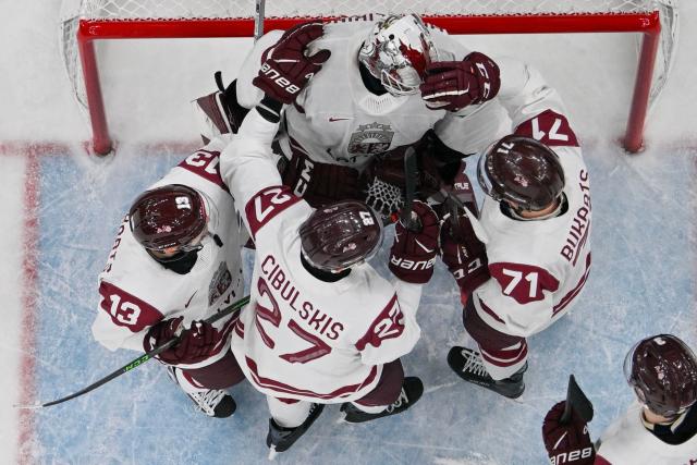 Latvia players react at the end of the men's qualification play-off ice hockey match between Sweden and Latvia at the Milano Santagiulia Ice Hockey Arena during the Milano Cortina 2026 Winter Olympic Games in Milan, on February 17, 2026. (Photo by Alexander NEMENOV / AFP)