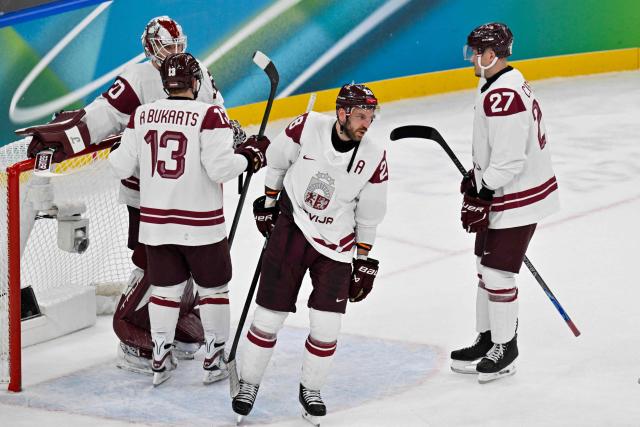 Latvia's #28 Zemgus Girgensons (C) reacts at the end of the men's qualification play-off ice hockey match between Sweden and Latvia at the Milano Santagiulia Ice Hockey Arena during the Milano Cortina 2026 Winter Olympic Games in Milan, on February 17, 2026. (Photo by Alexander NEMENOV / AFP)