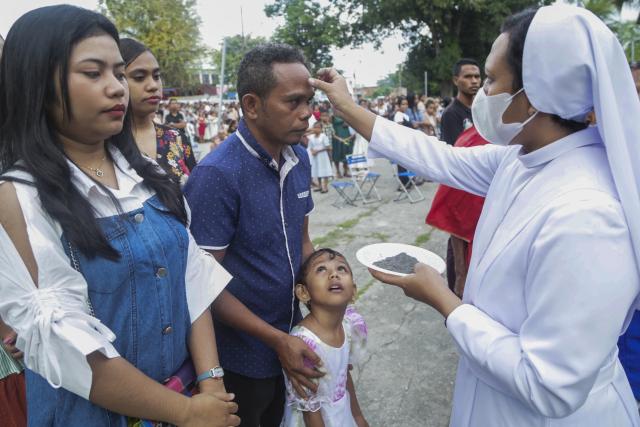 Catholic devotees receive a sign of the cross on their foreheads during an Ash Wednesday service at Balide church in Dili on February 18, 2026. (Photo by VALENTINO DARIELL DE SOUSA / AFP)