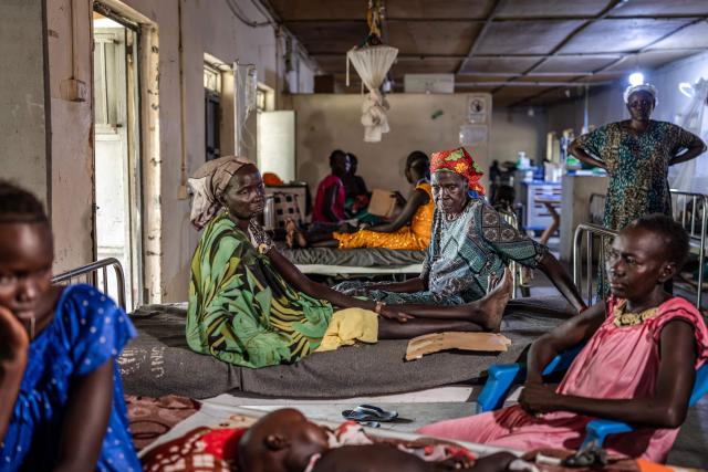 Women surround the bed of a baby who was allegedly shot during clashes between the South Sudan People’s Defence Forces (SSPDF) and the South Sudan People’s Liberation Army in Opposition (SPLA-IO) at Akobo Teaching Hospital in the strategic opposition-controlled town of Akobo, Jonglei State, on February 12, 2026. South Sudan gained independence in 2011 but quickly descended into civil war between rival generals, Salva Kiir and Riek Machar. A power-sharing deal in 2018 brought relative peace, with Kiir as president and Machar his deputy. But the deal was never fully implemented, their forces never unified, and elections never held. Over the past year, Machar has been jailed and violence has erupted between their forces in several areas. The worst has been in Jonglei state, where some 280,000 people have been displaced since December, according to the United Nations. (Photo by Luis TATO / AFP)