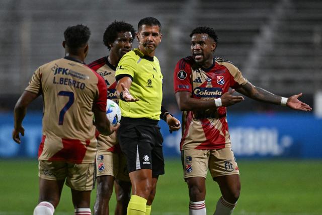 Independiente Medellin's defender #02 Leyser Chaverra (R) complains to Brazilian referee Bruno Arleu after he sent off Independiente Medellin's coach Alejandro Restrepo during the Copa Libertadores phase two first-leg football match between Uruguay's Liverpool and Colombia's Independiente Medellin at the Alfredo Victor Viera Park Stadium in Montevideo on February 17, 2026. (Photo by Eitan ABRAMOVICH / AFP)
