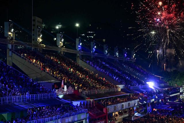 Spectators watch from the stands the closing night of the Rio Carnival at the Marques de Sapucai Sambadrome in Rio de Janeiro, Brazil on February 17, 2026. (Photo by Pablo PORCIUNCULA / AFP)
