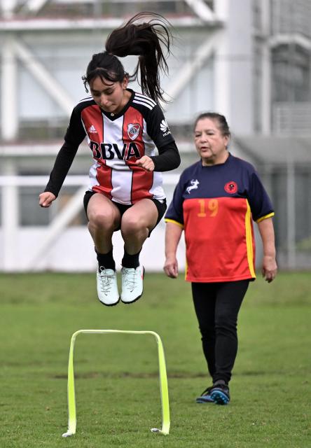 Daysha Flores (L) and retired teacher Angelica Aguirre, 73, take part in a training session during the Women’s Football Comprehensive Training Programme at the Catholic University in Quito on February 4, 2026. The Centre for Knowledge Transfer and Social Innovation at the Catholic University of Quito fosters a safe and inclusive space in which women can participate in the football team, regardless of their age. (Photo by Rodrigo BUENDIA / AFP)