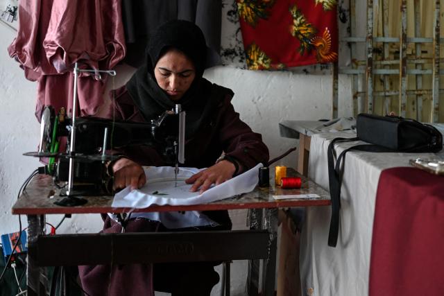 This photograph taken on January 20, 2026 shows Afghan tailoress Rahima Alavi embroidering a scarf at her boutique in Bamiyan. With women banned from most jobs in Afghanistan, an embroidery boutique run by 22-year-old Alavi is a surprising and treasured sight in Bamiyan. Alavi is one of more than five million people who returned to the country since 2023 from neighbouring Iran and Pakistan, which have been pushing back Afghans after decades of hosting them. (Photo by Wakil KOHSAR / AFP) / To go with 'Afghanistan-Women-Migration-Economy', REPORTAGE