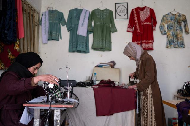 TOPSHOT - This photograph taken on January 20, 2026 shows Afghan tailoress Rahima Alavi (L) embroidering scarves and clothes at her boutique in Bamiyan. With women banned from most jobs in Afghanistan, an embroidery boutique run by 22-year-old Alavi is a surprising and treasured sight in Bamiyan. Alavi is one of more than five million people who returned to the country since 2023 from neighbouring Iran and Pakistan, which have been pushing back Afghans after decades of hosting them. (Photo by Wakil KOHSAR / AFP) / To go with 'Afghanistan-Women-Migration-Economy', REPORTAGE