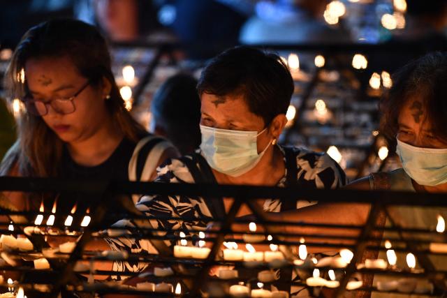 Catholic devotees light candles as they pray at a chapel on Ash Wednesday at a church ground in Manila on February 18, 2026. (Photo by Ted ALJIBE / AFP)