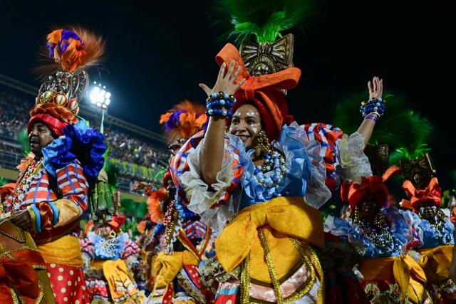 Revellers of the Unidos de Vila Isabel samba school perform during the closing night of the Rio Carnival at the Marques de Sapucai Sambadrome in Rio de Janeiro, Brazil, early on February 18, 2026. (Photo by Pablo PORCIUNCULA / AFP)