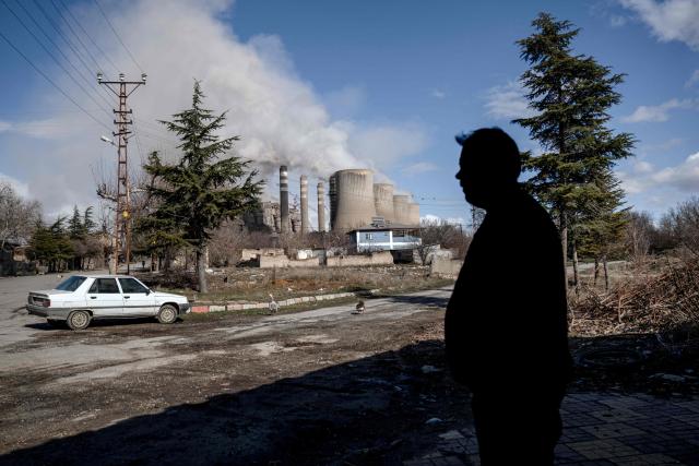 A resident walks on a street as clouds of water vapor rise from the Afsin-Elbistan coal-based power plant in the nearby village of Cogulhan on February 11, 2026. The power plant has operated since 1984 and is one of Turkey's largest thermal facilities, with eight units generating 2,795 megawatts. It relies on lignite from the Afsin?Elbistan basin, which holds around 40 percent of the country's known reserves. Environmental groups say they are alarmed by government plans to expand Plant A with two new units as part of efforts to reduce reliance on energy imports. (Photo by Ozan KOSE / AFP)