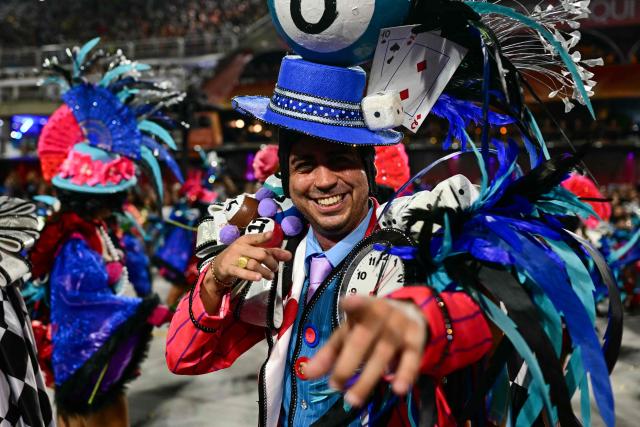 A reveller of the Unidos de Vila Isabel samba school performs during the closing night of the Rio Carnival at the Marques de Sapucai Sambadrome in Rio de Janeiro, Brazil, early on February 18, 2026. (Photo by Pablo PORCIUNCULA / AFP)