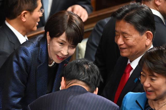 Japan's Prime Minister and Liberal Democratic Party (LDP) President Sanae Takaichi (2nd L) chats with party members at a plenary session of the Lower House of Parliament in Tokyo on February 18, 2026. (Photo by Kazuhiro NOGI / AFP)