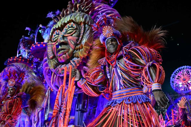 A reveller of the Academicos do Grande Rio samba school performs on a float during the closing night of the Rio Carnival at the Marques de Sapucai Sambadrome in Rio de Janeiro, Brazil, early on February 18, 2026. (Photo by Pablo PORCIUNCULA / AFP)