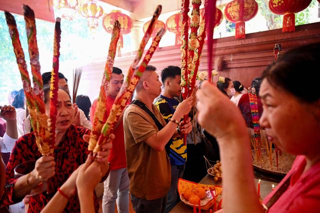 People burn incense and pray at a temple on the second day of the Lunar New Year of the Horse in Phnom Penh on February 18, 2026. (Photo by TANG CHHIN Sothy / AFP)