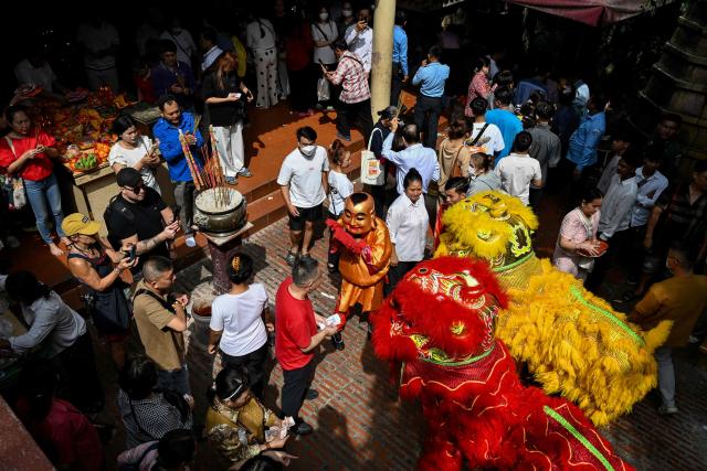 Lion dancers perform as people pray at a temple on the second day of the Lunar New Year of the Horse in Phnom Penh on February 18, 2026. (Photo by TANG CHHIN Sothy / AFP)