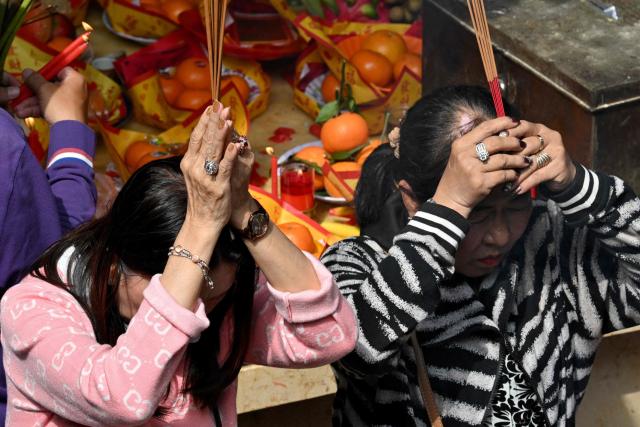 People burn incense and pray at a temple on the second day of the Lunar New Year of the Horse in Phnom Penh on February 18, 2026. (Photo by TANG CHHIN Sothy / AFP)