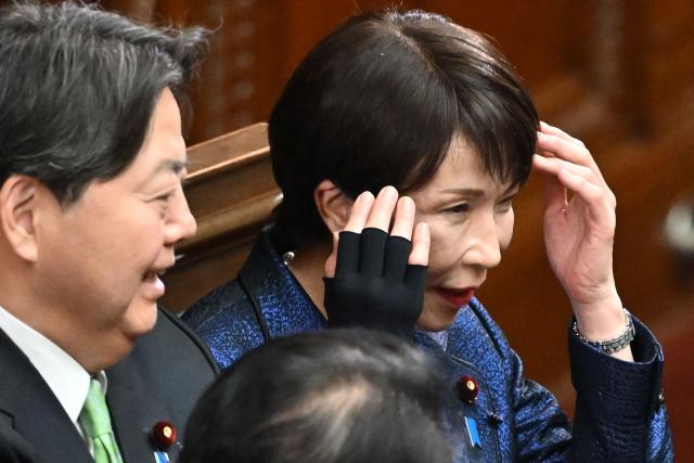Liberal Democratic Party (LDP) President Sanae Takaichi (R) reacts after she was reappointed as Japan's prime minister at the plenary session of the Lower House of Parliament in Tokyo on February 18, 2026. (Photo by Kazuhiro NOGI / AFP)