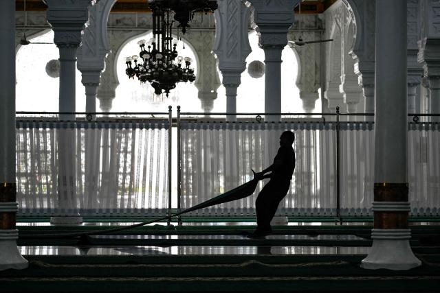 A worker prepares for the first prayer of the Muslim holy month of Ramadan at the Baiturrahman GrandMmosque in Banda Aceh on February 18, 2026. (Photo by CHAIDEER MAHYUDDIN / AFP/Chaideer MAHYUDDIN / AFP)