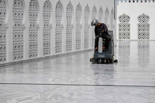 A worker cleans the Baiturrahman Grand Mosque ahead of the Muslim holy month of Ramadan in Banda Aceh on February 18, 2026. (Photo by CHAIDEER MAHYUDDIN / AFP/Chaideer MAHYUDDIN / AFP)