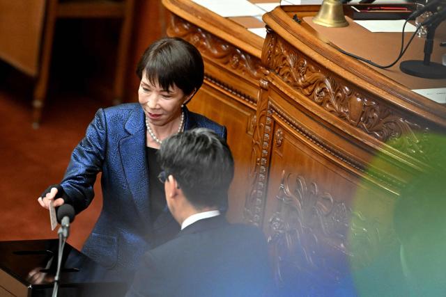 Liberal Democratic Party (LDP) President Sanae Takaichi (L) votes in the Prime Minister nomination election at a plenary session of the Lower House of Parliament in Tokyo on February 18, 2026. (Photo by Kazuhiro NOGI / AFP)