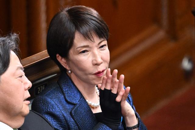 Liberal Democratic Party (LDP) President Sanae Takaichi (R) attends the Prime Minister nomination election during the a plenary session of the Lower House of Parliament in Tokyo on February 18, 2026. (Photo by Kazuhiro NOGI / AFP)