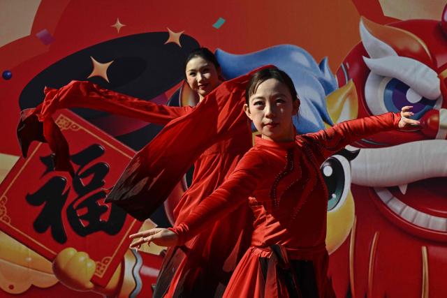 Dancers perform at a fair in a park on the second day of the Lunar New Year of the Horse in Beijing on February 18, 2026. (Photo by Pedro PARDO / AFP)
