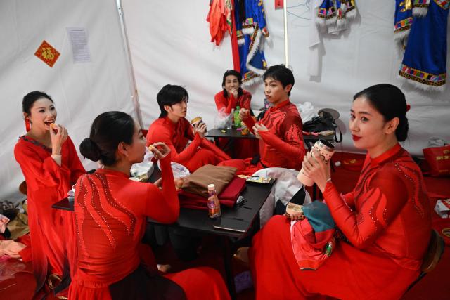 Dancers prepare to perform at a fair in a park on the second day of the Lunar New Year of the Horse in Beijing on February 18, 2026. (Photo by Pedro PARDO / AFP)