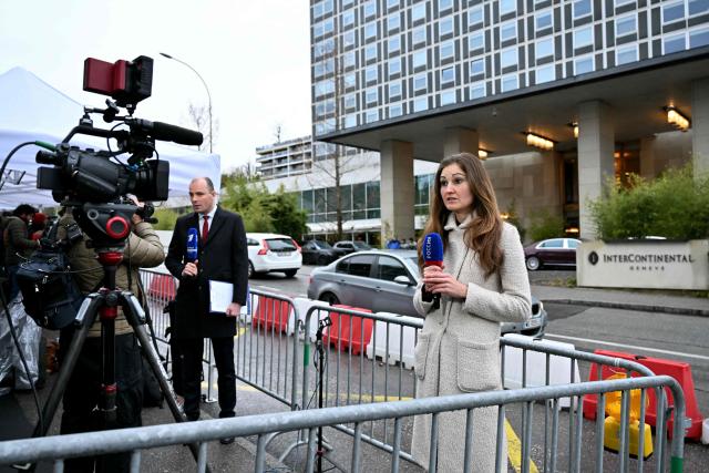 Journalists report outside the hotel where is taking place a second day of Omani-mediated talks between the US and Iran aimed at averting the possibility of US military intervention to curb Iran's nuclear programme, weeks after the cleric-run state killed thousands of people as it crushed mass demonstrations, in Geneva on February 18, 2026.  (Photo by Harold CUNNINGHAM / AFP)