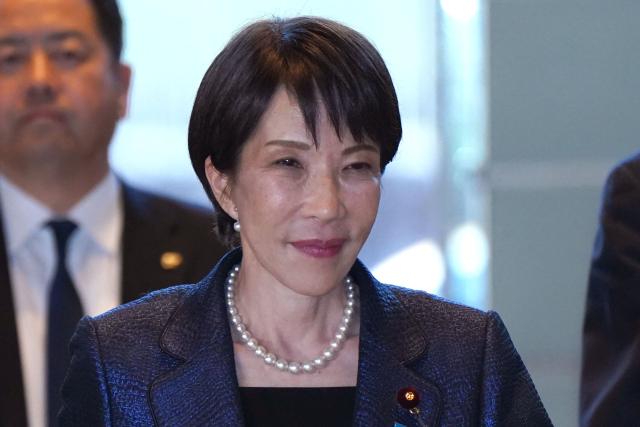 Japan's Prime Minister and Liberal Democratic Party (LDP) President Sanae Takaichi (R) enters the Prime Minister's Office after being appointed by the parliament, in Tokyo on February 18, 2026. (Photo by Kazuhiro NOGI / AFP)