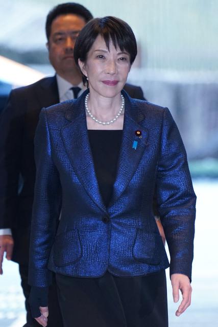 Japan's Prime Minister and Liberal Democratic Party (LDP) President Sanae Takaichi (R) enters the Prime Minister's Office after being appointed by the parliament, in Tokyo on February 18, 2026. (Photo by Kazuhiro NOGI / AFP)