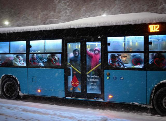 People ride a bus under heavy snowfall in Bucharest, Romania, on February 18, 2026. Romanian authorities issued a Code Orange warning for several counties, as heavy snowfall and blizzard conditions disrupted transport and forced schools to close across the country's southern and eastern regions. (Photo by Daniel MIHAILESCU / AFP)