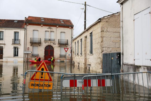 Rescuers navigate on a bark on a flooded street following the flood of the Charente river in Saintes, western France, on February 18, 2026. Charente-Maritime, Gironde, Lot-et-Garonne and Maine-et-Loire remain on red alert for flooding until at least February 19, 2026, Vigicrues announced on February 18, 2026, indicating that nine departments are on orange alert for flooding or rain-related flooding as Storm Pedro approaches. (Photo by ROMAIN PERROCHEAU / AFP)