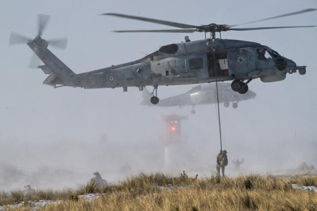 Soldiers in helicopters take part in NATO's STEADFAST DART 26 exercise in Putlos, Germany, on February 18, 2026. (Photo by Fabian Bimmer / POOL / AFP)