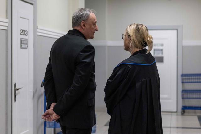 Andrzej Jez (L), bishop of the Diocese of Tarnów in Poland, waits with his lawyer Monika Brzozowska-Pasieka (R) in a court corridor to be questioned by the district court in Tarnów, Poland, where he is accused of allegedly covering up paedophilia by priests in his diocese, on February 18, 2026. The Bishop of Tarnow Andrzej Jez is the first member of the hierarchy to face criminal charges for failing to inform authorities of abuse by clergy. (Photo by Wojtek RADWANSKI / AFP)