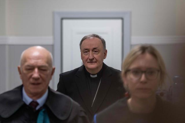 Andrzej Jez (C), bishop of the Diocese of Tarnów in Poland, waits with his lawyers Zbigniew Cwiakalski (L) and Monika Brzozowska-Pasieka (R) in a court corridor to be questioned by the district court in Tarnów, Poland, where he is accused of allegedly covering up paedophilia by priests in his diocese, on February 18, 2026. The Bishop of Tarnow Andrzej Jez is the first member of the hierarchy to face criminal charges for failing to inform authorities of abuse by clergy. (Photo by Wojtek RADWANSKI / AFP)