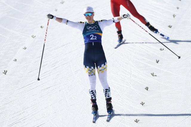 Sweden's Maja Dahlqvist celebrates crossing the finish line ahead of Switzerland's Nadine Faehndrich for Sweden to win gold in the women's team cross country free sprint final event of the Milano Cortina 2026 Winter Olympic Games at Tesero Cross-Country Skiing Stadium in Lago di Tesero (Val di Fiemme), on February 18, 2026. (Photo by Anne-Christine POUJOULAT / AFP)