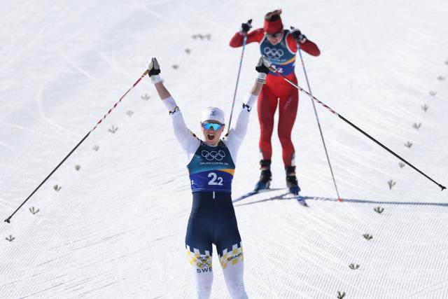 Sweden's Maja Dahlqvist celebrates after crossing the finish line ahead of Switzerland's Nadine Faehndrich for Sweden to win gold in the women's team cross country free sprint final event of the Milano Cortina 2026 Winter Olympic Games at Tesero Cross-Country Skiing Stadium in Lago di Tesero (Val di Fiemme), on February 18, 2026. (Photo by Anne-Christine POUJOULAT / AFP)