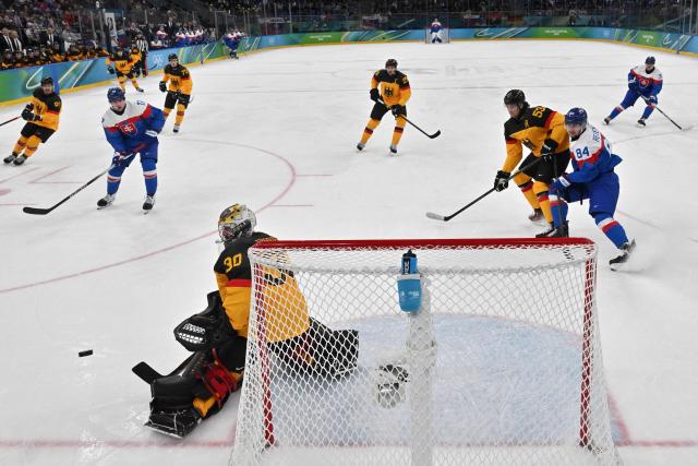 Germany's #30 Philipp Grubauer deflects the puck during the men's play-off quarter-final ice hockey match between Slovakia and Germany at the Milano Santagiulia Ice Hockey Arena during the Milano Cortina 2026 Winter Olympic Games in Milan, on February 18, 2026. (Photo by Alexander NEMENOV / POOL / AFP)