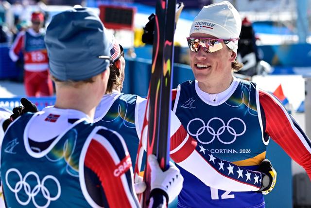 USA's Gus Schumacher (2ndL) congratulates Norway's Johannes Hoesflot Klaebo after Sweden won gold during the men's team cross country free sprint final event of the Milano Cortina 2026 Winter Olympic Games at Tesero Cross-Country Skiing Stadium in Lago di Tesero (Val di Fiemme), on February 18, 2026. (Photo by Tobias SCHWARZ / AFP)