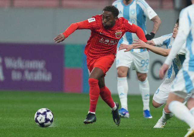 Shanghai Port’s midfielder Gabriel zinho (L) controls the ball ahead of Ulsan HD players during their AFC Champions League football match in Shanghai on February 18, 2026. (Photo by CN-STR / AFP) / China OUT