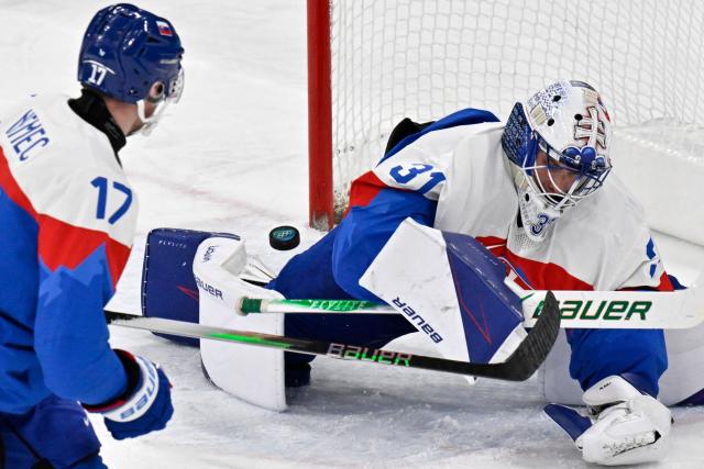 Slovakia's #31 Samuel Hlavaj (R) and Slovakia's #17 Simon Nemec fail to save the puck as Germany's #95 Frederik Tiffels (not pictured) scores his team's second goal during the men's play-off quarter-final ice hockey match between Slovakia and Germany at the Milano Santagiulia Ice Hockey Arena during the Milano Cortina 2026 Winter Olympic Games in Milan, on February 18, 2026. (Photo by Alexander NEMENOV / AFP)