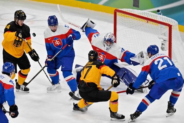 Players vie for the puck during the men's play-off quarter-final ice hockey match between Slovakia and Germany at the Milano Santagiulia Ice Hockey Arena during the Milano Cortina 2026 Winter Olympic Games in Milan, on February 18, 2026. (Photo by Alexander NEMENOV / AFP)