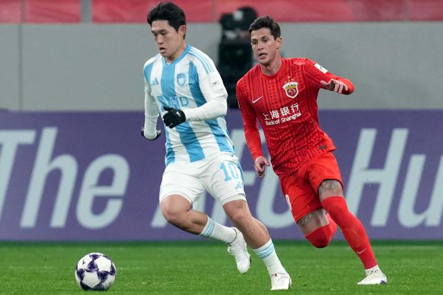 Shanghai Port's midfielder Mateus Vital (R) fights for the ball with Ulsan HD's midfielder Lee Dong-gyeong during their AFC Champions League football match in Shanghai on February 18, 2026. (Photo by CN-STR / AFP) / China OUT