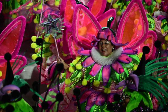 A reveller of the Academicos do Salgueiro samba school performs during the closing night of the Rio Carnival at the Marques de Sapucai Sambadrome in Rio de Janeiro, Brazil, early on February 18, 2026. (Photo by Pablo PORCIUNCULA / AFP)