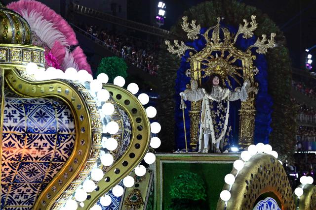 A reveller of the Academicos do Salgueiro samba school performs during the closing night of the Rio Carnival at the Marques de Sapucai Sambadrome in Rio de Janeiro, Brazil, early on February 18, 2026. (Photo by Pablo PORCIUNCULA / AFP)