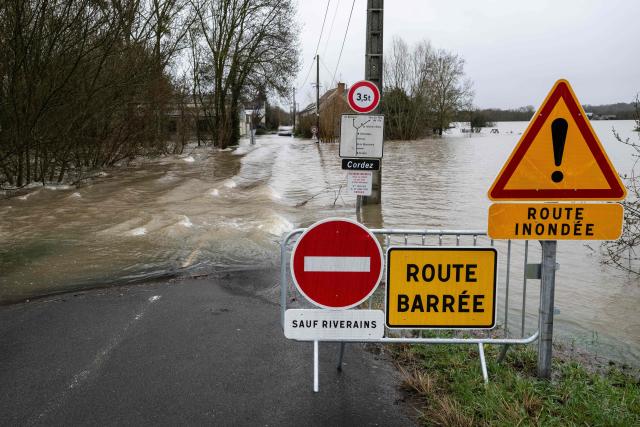 This photograph shows a flooded road in Chalonnes-sur-Loire, western France on February 18, 2026. The new rains expected on February 18 and 19, 2026 with Storm Pedro will ‘replenish the current floods’ or ‘maintain them,’ warned Lucie Chadourne-Facon, director of Vigicrues, on Wednesday, as four departments in western France are on red alert. (Photo by Sebastien Salom-Gomis / AFP)