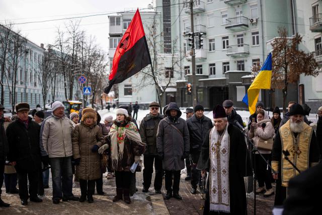 People attend a memorial service honouring the victims of the peaceful march to the Ukrainian Verkhovna Rada on February 18, 2014, during the mass Euromaidan protests, in Kyiv on February 18, 2026, amid the Russian invasion of Ukraine. (Photo by HENRY NICHOLLS / AFP)