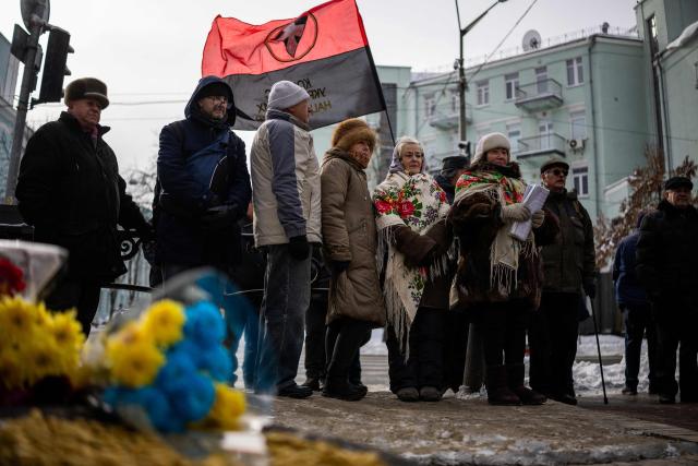 People attend a memorial service honouring the victims of the peaceful march to the Ukrainian Verkhovna Rada on February 18, 2014, during the mass Euromaidan protests, in Kyiv on February 18, 2026, amid the Russian invasion of Ukraine. (Photo by HENRY NICHOLLS / AFP)