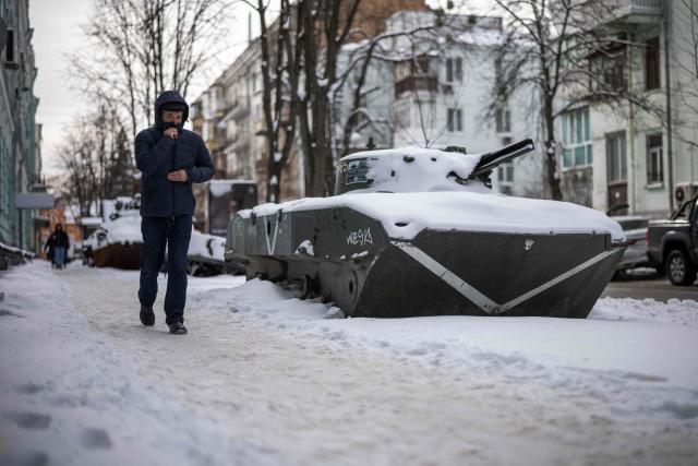 A person walks past a captured Russian armoured vehicle on display in Kyiv on February 18, 2026, amid the Russian invasion of Ukraine. (Photo by HENRY NICHOLLS / AFP)